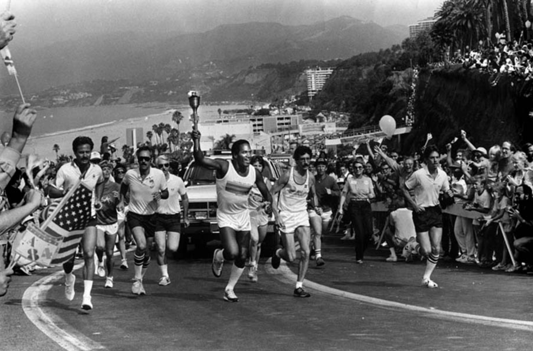 “O.J. Simpson, carrying the Olympic torch in 1984. Nicole Brown is off to the left.”